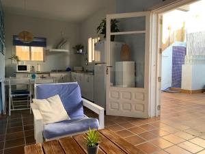 a living room with a chair and a kitchen at "NeW" Casita Azul in Denia