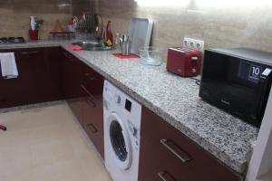 a kitchen with a counter top with a microwave and a dishwasher at New Fez Apartments in Fez