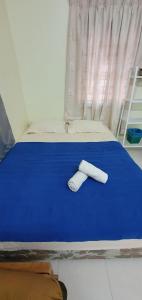 uma cama com duas toalhas numa cama azul em ABAH HOMESTAY Kuala Terengganu em Kuala Terengganu