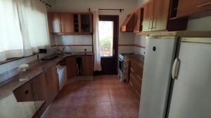 una cucina con mobili in legno e un frigorifero bianco di La Romeria a Punta del Este