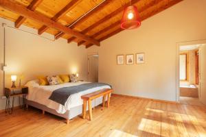1 dormitorio con cama y techo de madera en Bog Antilhue - Casa 2 cuartos en Villa La Angostura
