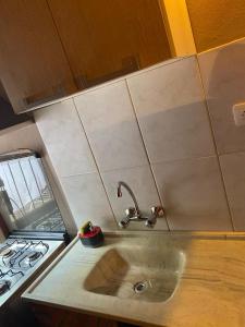 a kitchen counter with a sink and a stove at ApartCabañas Centro. Ubicación inmejorable in Puerto Iguazú