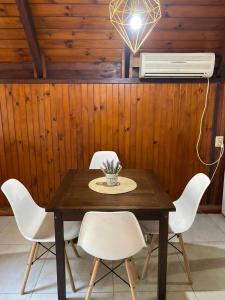 a dining room table with white chairs and a fan at ApartCabañas Centro. Ubicación inmejorable in Puerto Iguazú