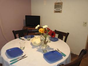 a white table with blue plates and flowers on it at My Sweet Home Calafate in El Calafate