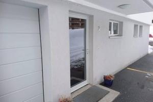 a white building with a door and a window at Mireille, Appartment 61 in Leukerbad