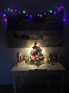 Un árbol de Navidad sentado en una mesa con luces en Pit Lane AFFITTACAMERE, en Offida