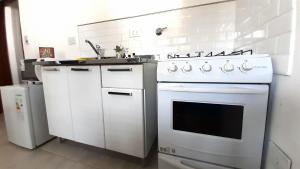 a kitchen with a white stove and a sink at Amplios Departamentos en Corrientes in Corrientes