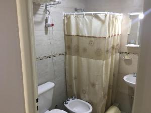 a small bathroom with a toilet and a sink at Nikemen, moderno dpto con patio y cochera cubierta in Neuquén