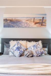 1 cama con almohadas y una foto de playa en 1 Private Queen room in Carramar 1 Minute Walk To Station, en Sídney