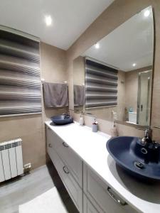 łazienka z umywalką i dużym lustrem w obiekcie Nur Apartment w mieście Terrassa