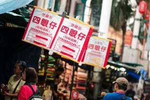 a group of signs are hanging on a street at EXPRESSIONZ KLCC BY G Suites in Kuala Lumpur