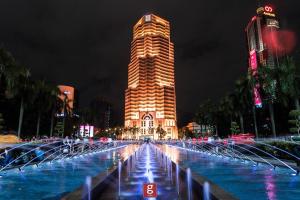 a tall building with a fountain in front of it at EXPRESSIONZ KLCC BY G Suites in Kuala Lumpur