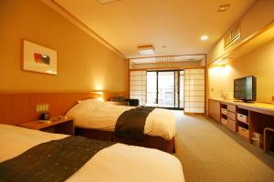 um quarto de hotel com duas camas e uma televisão em Mizunoto em Hakone