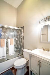 a bathroom with a white toilet and a sink at Newly Renovated Historic Savannah Townhome! in Savannah