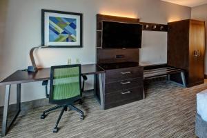 a hotel room with a desk and a television at Holiday Inn Express Hotel & Suites Jackson Northeast by IHG in Jackson