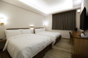 Postel nebo postele na pokoji v ubytování 原鄉商旅 Yuan Hsiang Hotel