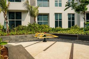 ジャカルタにあるMinimalist and Cozy 2BR Citralake Suites Apartment By Travelioの建物前の歩道に座る玩具飛行機