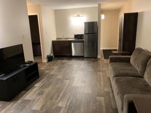 a living room with a couch and a kitchen at Airways Motel in Cold Lake