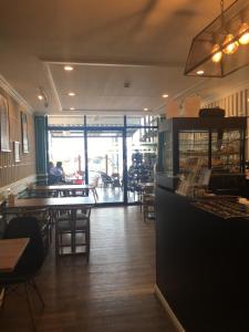 a restaurant with wooden tables and chairs and a counter at Nakhone Champa Hotel in Pakse