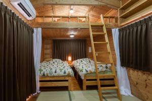 a bedroom with a bunk bed and a ladder at もとぶいこいの宿 やまちゃん in Motobu +38 photos