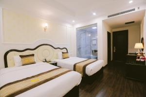 Cette chambre comprend deux lits et une salle de bains. dans l'établissement Vincent Halong Hotel, à Hạ Long