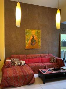 ein Wohnzimmer mit einem roten Sofa und einem Tisch in der Unterkunft Sliema La Loggia DeLuxe Suites in Sliema