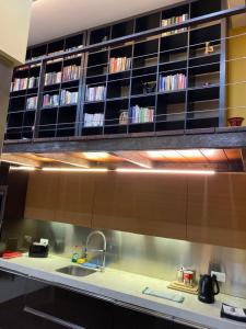 斯利馬的住宿－Sliema La Loggia DeLuxe Suites，厨房配有水槽和带DVD播放机的书架。
