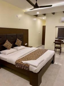 een slaapkamer met een groot bed en een tafel bij Tranquil Park in Pondicherry