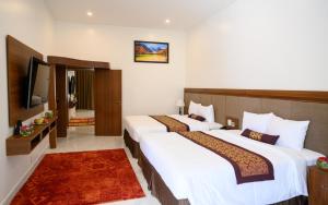 Postel nebo postele na pokoji v ubytování Nhat Quang Hotel