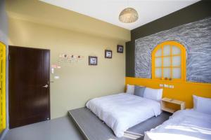 Rúm í herbergi á 東立方旅宿-East Cube B&B