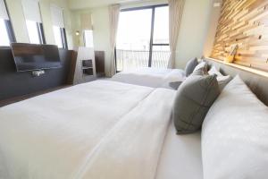 Rúm í herbergi á 東立方旅宿-East Cube B&B