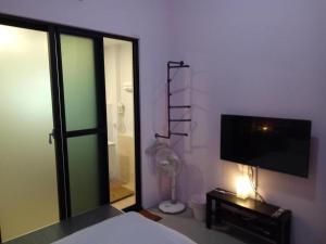 1 dormitorio con 1 cama y TV de pantalla plana en 東立方旅宿-East Cube B&B, en Donggang
