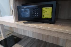un four micro-ondes installé au-dessus d'une étagère dans l'établissement The HO Hotel, à Hsinchu