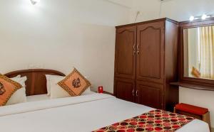 Swapnatheeram Beach Resort في كوفالام: غرفة نوم بسريرين وكابينة ومرآة