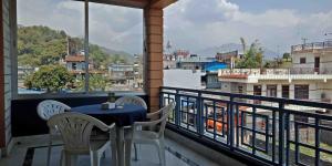stół i krzesła na balkonie z widokiem w obiekcie Hotel Nana Pokhara w mieście Pokhara