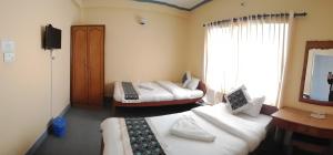 Kama o mga kama sa kuwarto sa Hotel Nana Pokhara