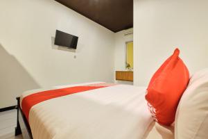 Tempat tidur dalam kamar di Super OYO 2519 Mayang Garini