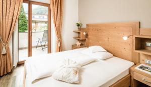 a bedroom with two white beds and a balcony at Nutzhof - Mediterran Flair Hotel in Lagundo