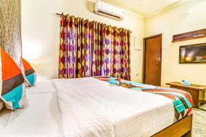 a bedroom with a large white bed and curtains at Fab Express Nestlay Rooms - Nr Ambattur Railway Station in Chennai
