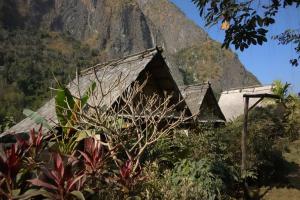 a house with a mountain in the background at Nong Kiau Riverside in Nongkhiaw