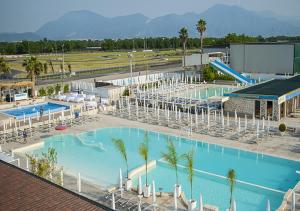 an overhead view of a large swimming pool with palm trees at Hotel Saturday in Palma Campania