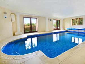 uma grande piscina com água azul numa casa em Baytree Lodge em Weymouth