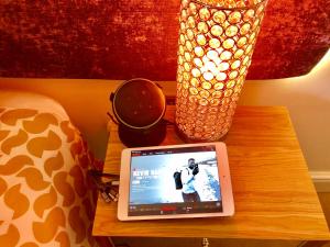a table with a laptop on a bedside table with a lamp at The Duplex with Air Conditioning & Private Deck Area in Margate