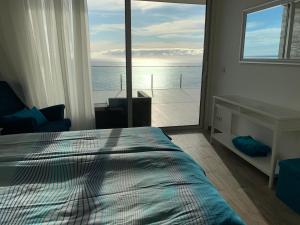 a bedroom with a bed and a view of the ocean at Holiday Apartment Ocean View in Ribeira Brava