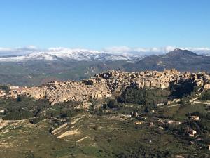 una vista aérea de una ciudad con montañas cubiertas de nieve en B&B Fleurs, en Enna