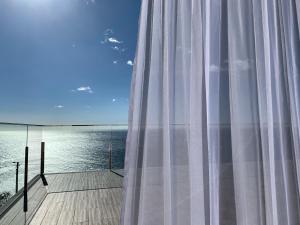 een raam met uitzicht op het water bij Holiday Apartment Ocean View in Ribeira Brava