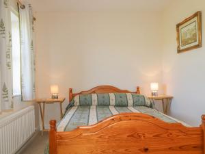 una camera con letto in legno e 2 comodini di Rowan Cottage a St Bees