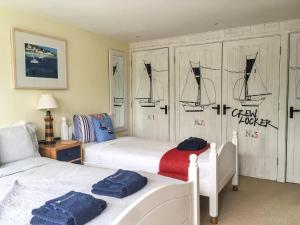 a bedroom with two beds and a wall with drawings on it at Daisy in Blackawton