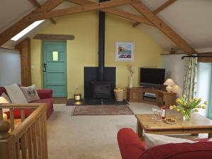 a living room with a fireplace and a tv at Daisy in Blackawton