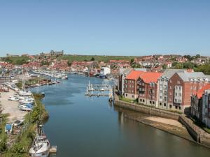 Blick auf einen Fluss mit Booten in einer Stadt in der Unterkunft Grays Cottage in Whitby